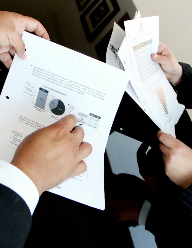 Pessoas analisando documentos e gráficos em reunião