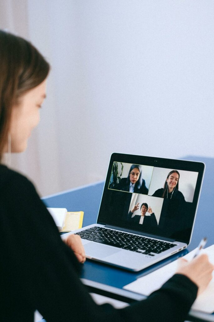 Mulher em videochamada com advogados pelo notebook