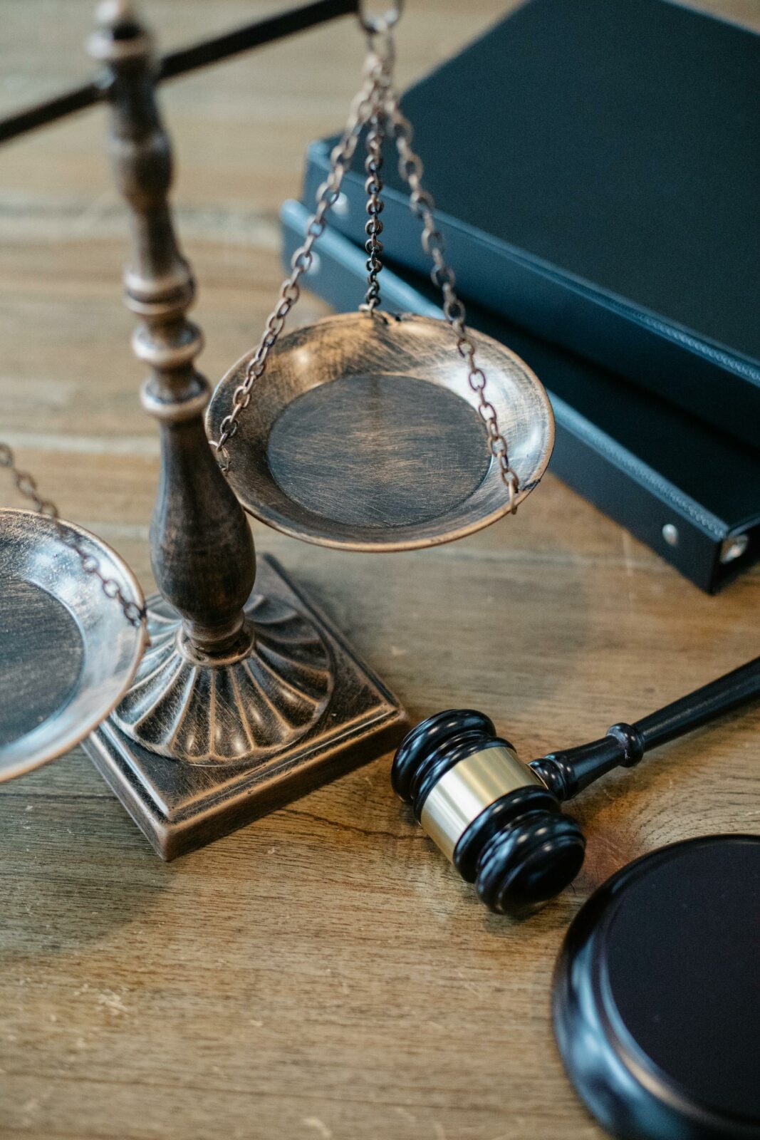 Balança da justiça e martelo de juiz sobre mesa de madeira
