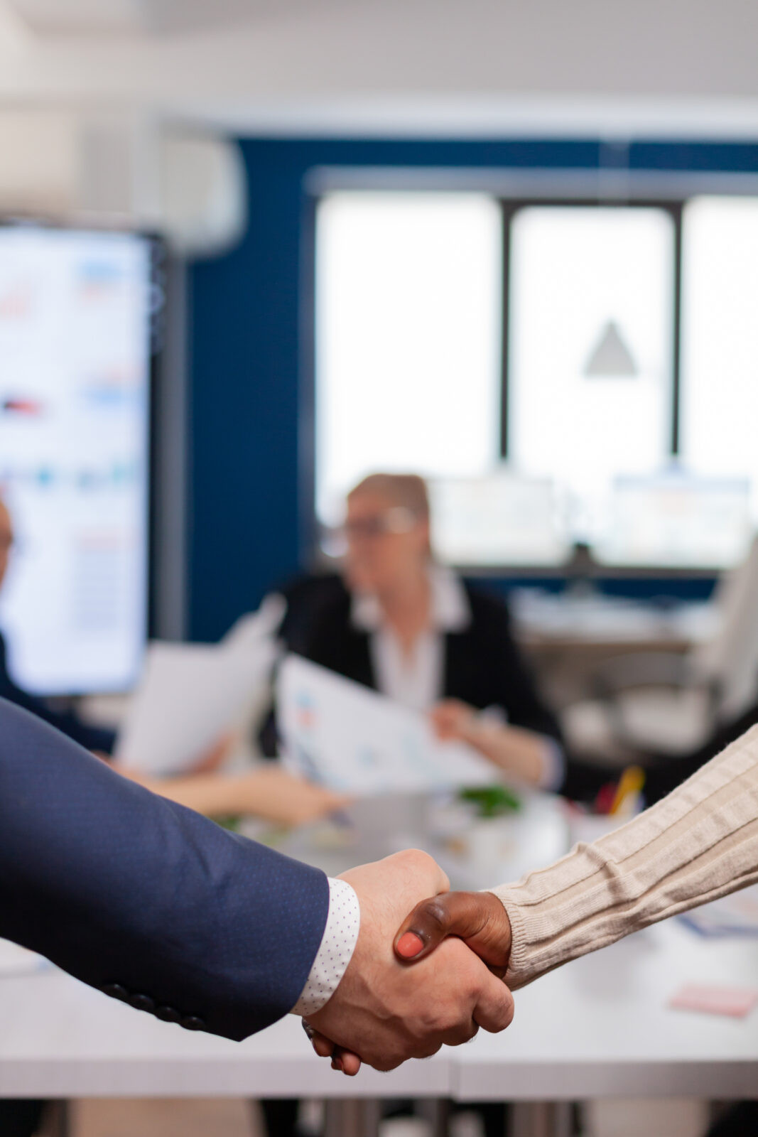 Sócios de empresas apertam as mãos após assinar um contrato de parceria
