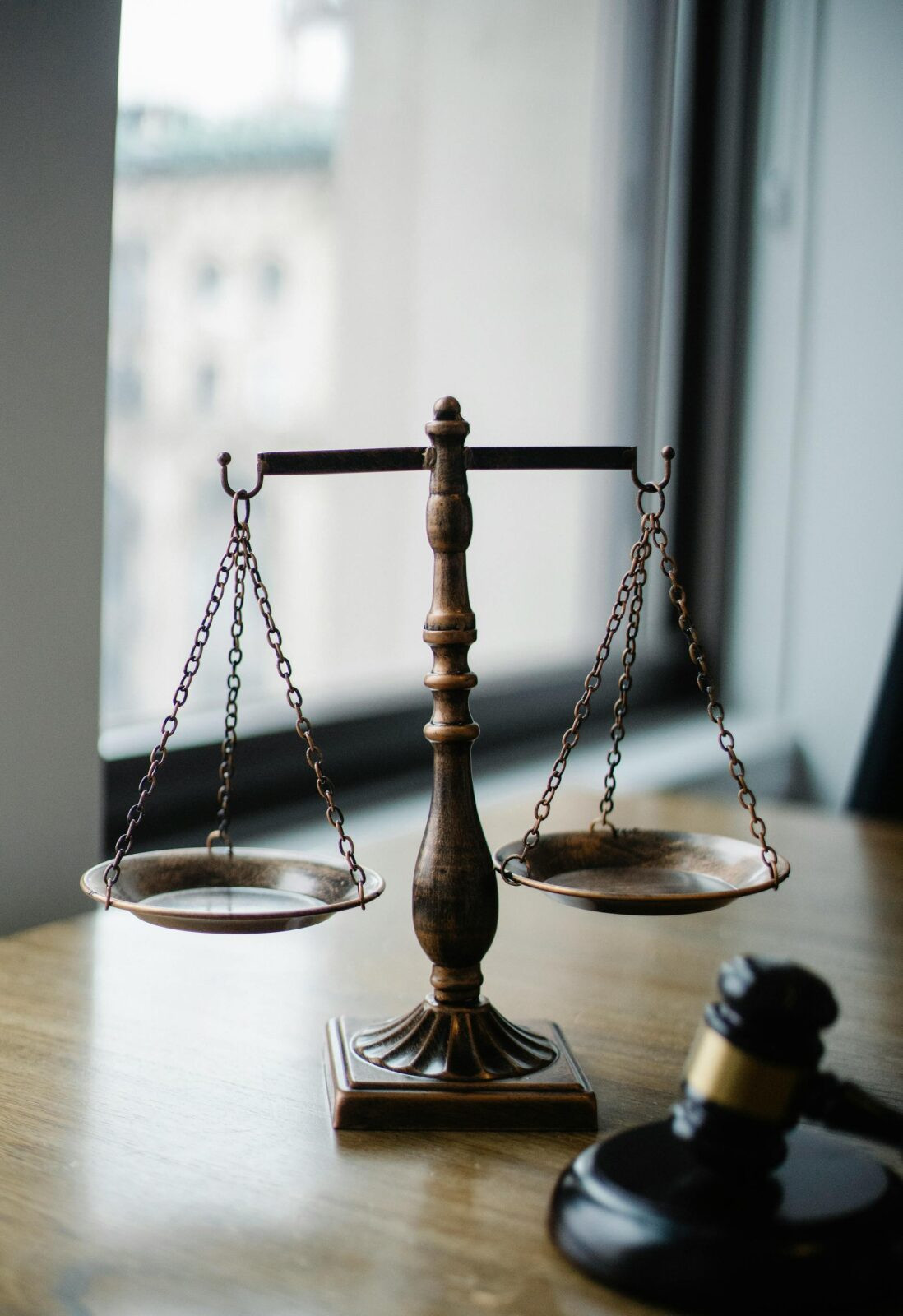 Balança da justiça e martelo de juiz sobre a mesa